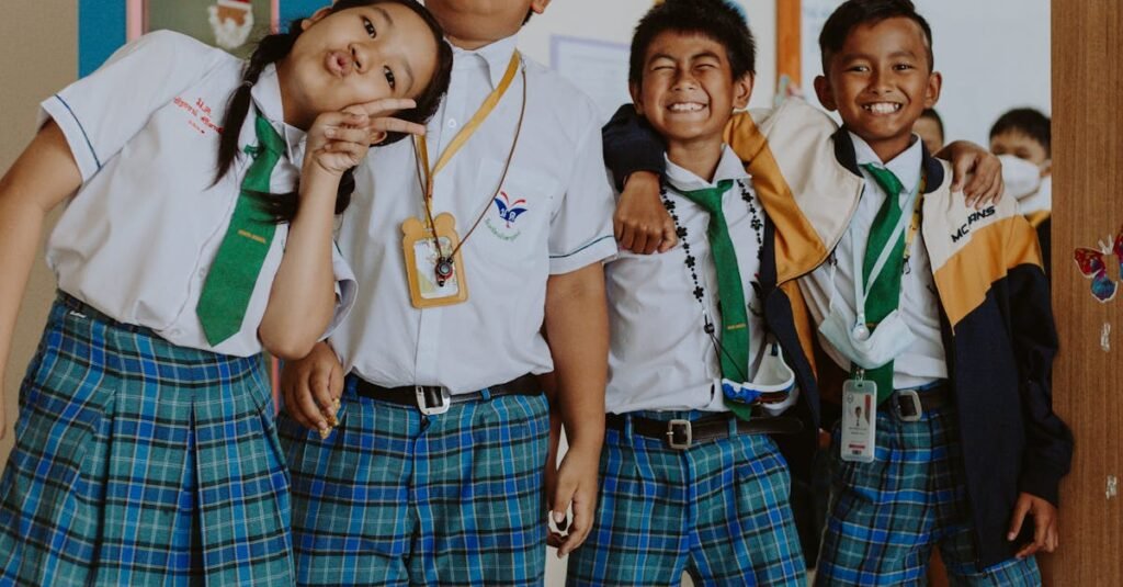 Happy group of students in school uniforms standing together in a classroom setting.